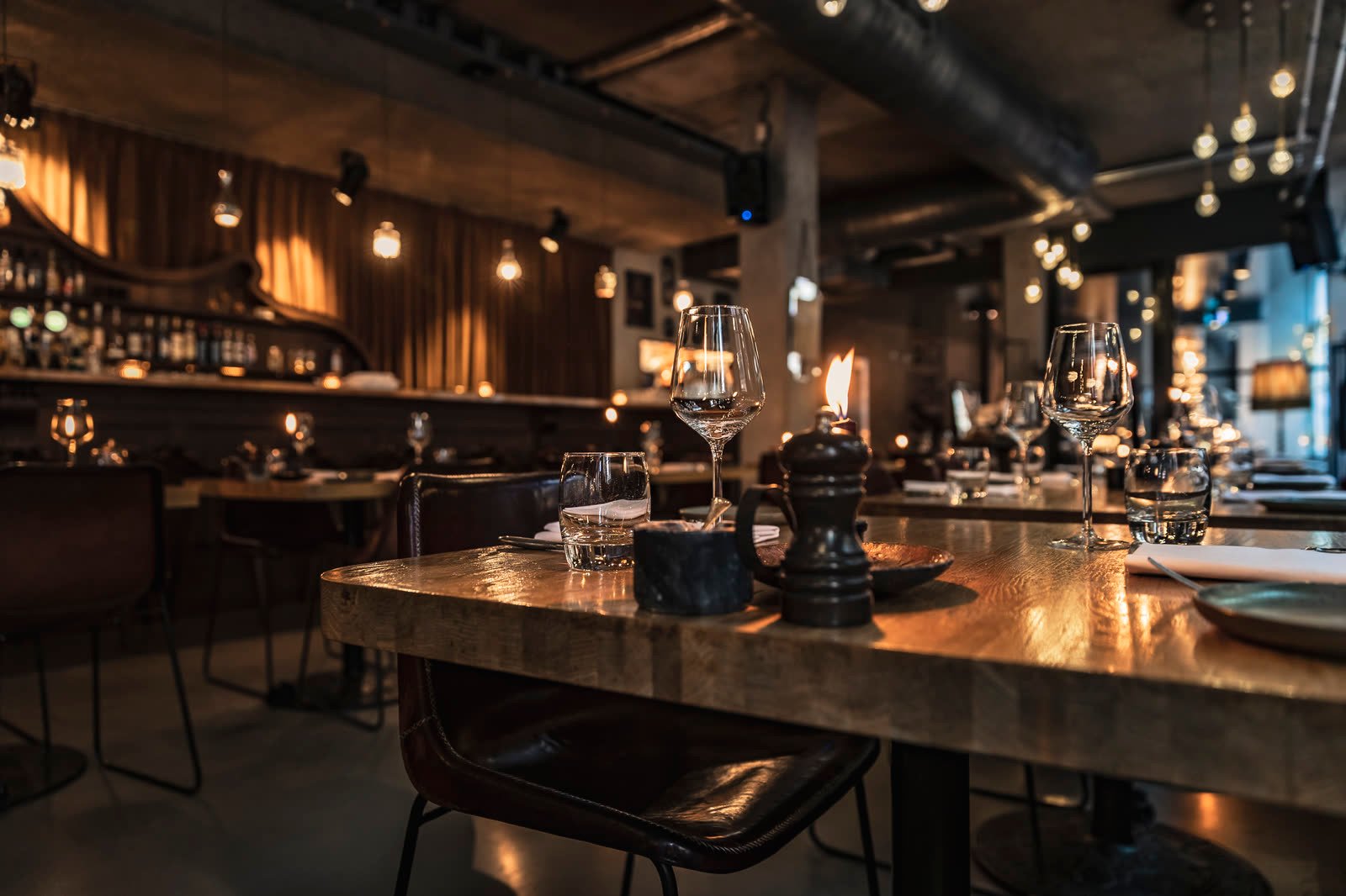 Gastraum am Abend, gedeckter Tisch im Kerzenlicht